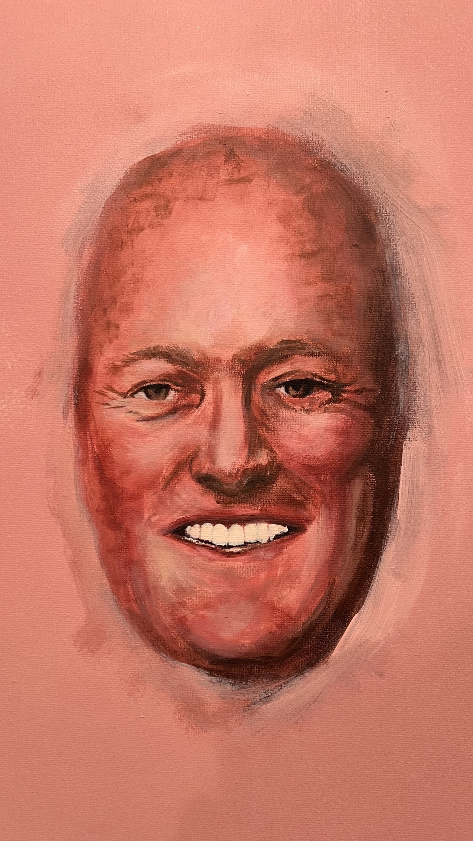 A realistic painting in progress depicts a smiling man with a textured, reddish-toned face against a pink background. If you squint, it looks a little bit like New Zealand’s best prime minister, Chris Luxon. 